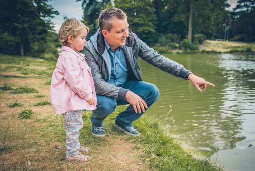 Séance Laetitia, Stéphane et Maëla, photo extérieur Bois de Vincennes, île de Reuilly et Île de Bercy, papa avec sa fille qui montre les canards