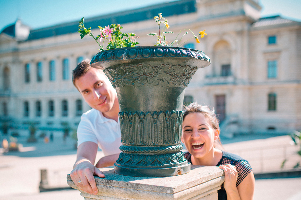 Séance Noéline et Florent, photo extérieure Jardin des plantes rire devant un pot de géranium