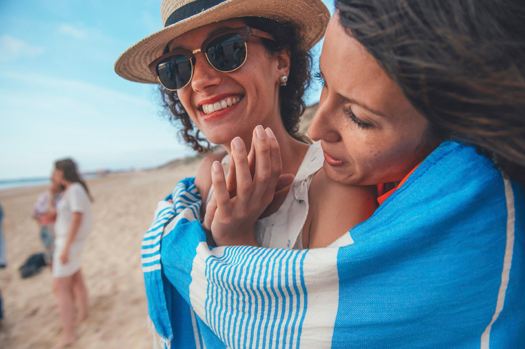 Mariage Ombeline et Albin, photo extérieure plage deux filles qui se serrent dans une couverture